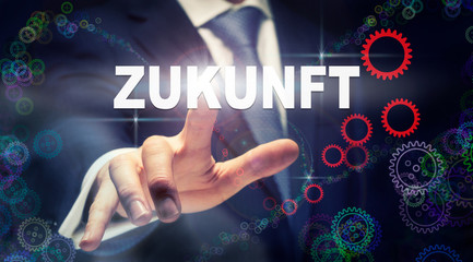 A businessman pressing a Future "Zukunft" button in German on a futuristic computer  display
