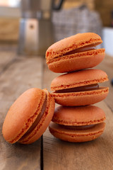 Orange macarons on a wooden table, with a vintage style.