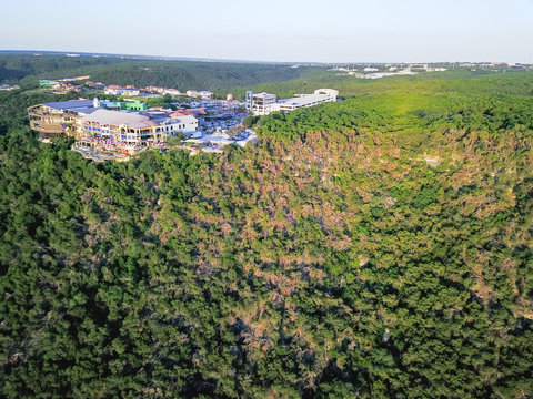 Bird eye view bluffs with colorful restaurant, luxury vacation homes near Lake Travis, Austin, Texas, USA. Vast lush green forest from above