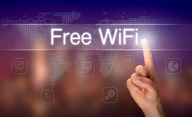 A hand selecting a Free WiFi business concept on a clear screen with a colorful blurred background.