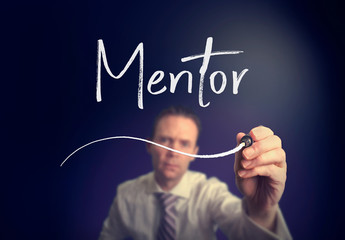 A businessman writing a mentor concept with a white pen on a clear screen.