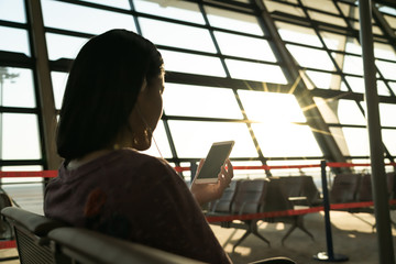 young women searching information while waiting for flying at airport window