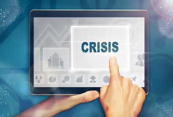 A hand selecting a crisis business concept on a computer tablet screen with a colorful background.