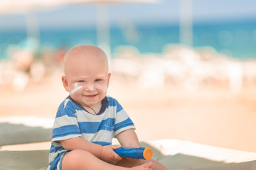 Cute baby boy with sunscreen on