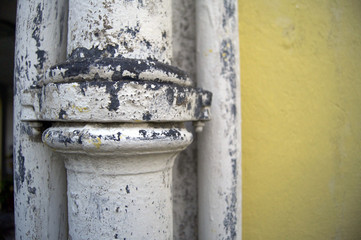 white piping metal outside a house.yellow wall
