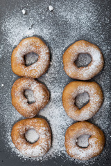 Fototapeta na wymiar Homemade donuts with icing sugar powder on a wooden background