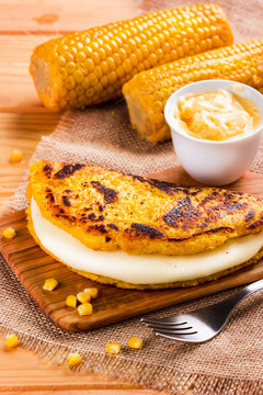 Wooden table with several ingredients for the preparation of Cachapas with cheese, corn, butter, ground corn and white cheese, Venezuelan Cuisine