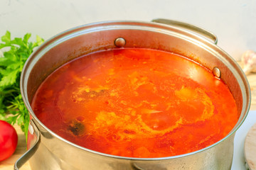 Pot with a homemade appetizing and tasty borsch. Red beetroot vegetable soup, boiling in a...