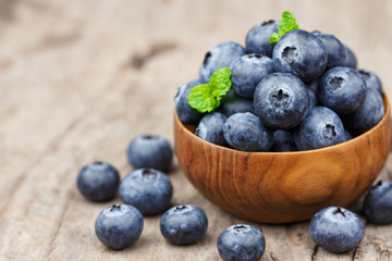 Blueberries in a wood bowl on a wooden table, Healthy eating and nutrition concept