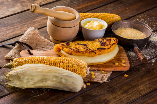 Typical Venezuelan cuisine, Top view of a wooden table with several ingredients for the preparation of Cachapas with cheese, corn, butter, ground corn and white cheese