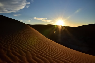 Fototapeta na wymiar Sonnenuntergang über eine Sanddüne