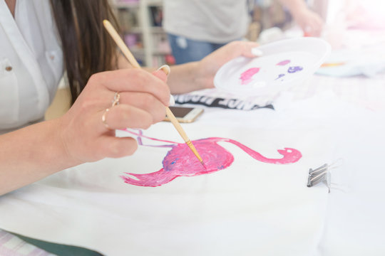 painting on fabric, flamingos on a vest. Drawing with paints.