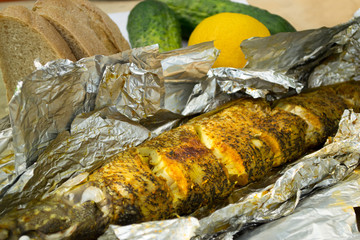 the baked pike served on a table with a lemon