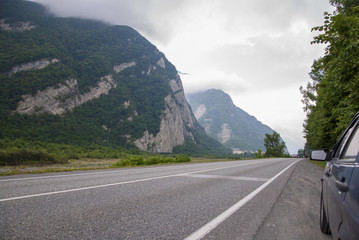 Naklejka premium Beautiful perspective on an asphalt road in the mountains with a car