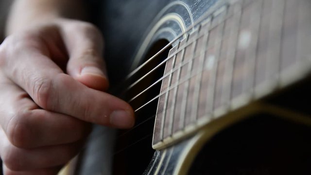 Plays the guitar closeup