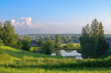 Fototapeta na wymiar Summer landscape, meadow pond and village