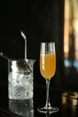 orange cocktail in a glass with ice on a dark background