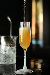 orange cocktail in a glass with ice on a dark background