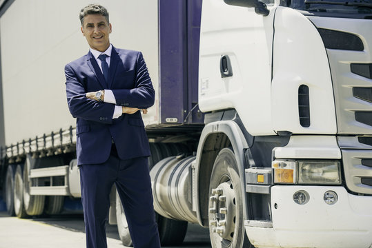Businessman standing in front of lorry