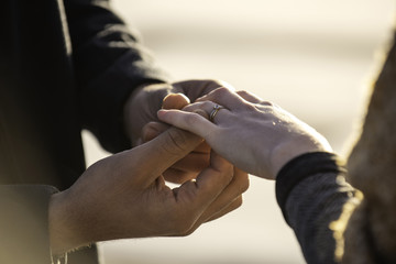 Man putting ring in his woman's finger