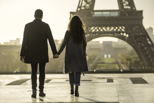 Couple holding hands near Eiffel Tower