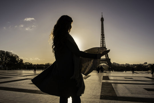 Woman reading map near Eiffel Tower