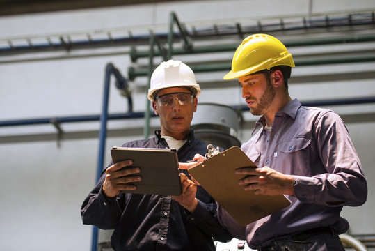 Factory workers discussing with each other in factory