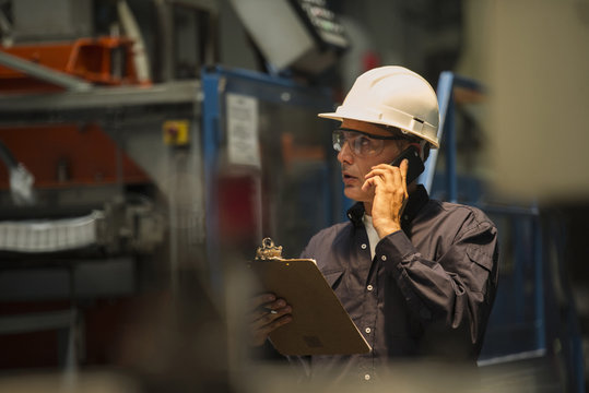 Factory worker using mobile phone in factory