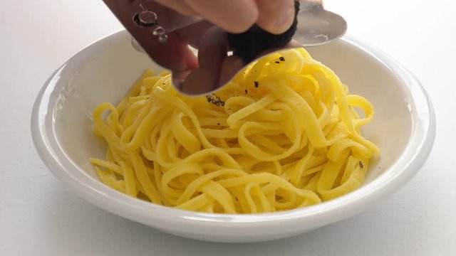 Egg pasta fettuccine, typical Italian, with fine black truffle grated on top