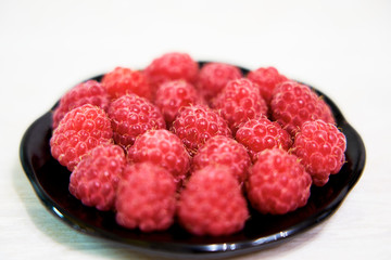 juicy fresh raspberries in a saucer