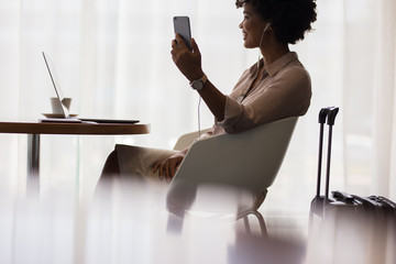 Woman at airport lounge making video call - Powered by Adobe