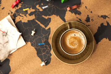 A cup of fragrant coffee on the map, a vintage photo. Travel and holidays. Copy space.