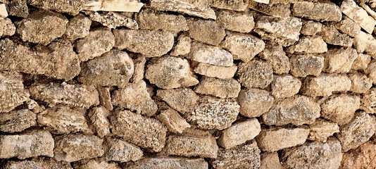 Stone Wall background from very old building contruction facade