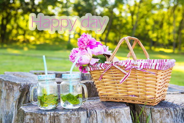 Straw basket with beautiful flowers and summer drinks-inscription happy day