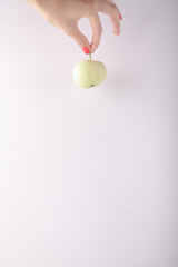 Fototapeta na wymiar Hand holding green apple on white background minimalism