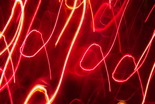 Blurred colorful lights in motion. Inversion. Abstract background in red tones