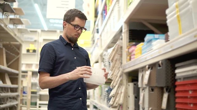 Customer holding a small plastic box for different kind of fasteners. Box for nails, bolts and screws. Small box for diffirent things at home.