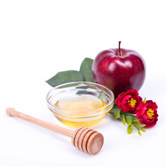 Rosh Hashanah Jewish holiday concept - honey, red apple, red flowers and dipper. traditional holiday symbols