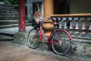 Bicicleta roja con cesta y sombrero aparcada en el tempo de Mua Caves en Ninh Binh, Vietnam