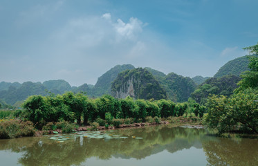 Vista de las montañas de Ninh Binh y su reflejo en el lago, Vietnam