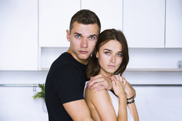 cute woman and man hugging in white kitchen, love