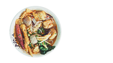 Top View of Chinese Noodle with Sausage, Tofu, Chicken Leg, Meatball / Pork Ball and Vegetables in A White Bowl.  Selective Focus and Isolated on White Background with Clipping Path or Selection Path.