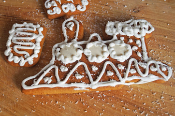 Christmas gingerbread decorated with white icing lie on a wooden table