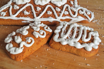 Christmas gingerbread decorated with white icing lie on a wooden table