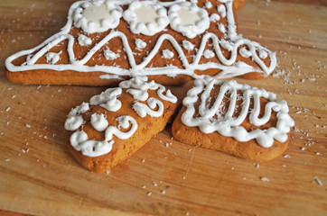 Christmas gingerbread decorated with white icing lie on a wooden table