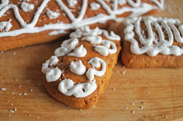 Christmas gingerbread decorated with white icing lie on a wooden table