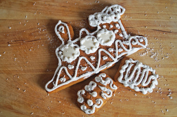 Christmas gingerbread decorated with white icing lie on a wooden table