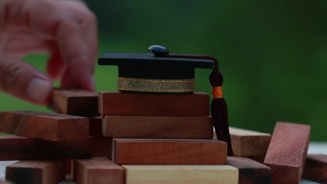 Graduation celebrating cap on wooden square blocks tower. Blank space for letter e.g education, study plan, graduate, etc. Ideas for Successive business abroad international Educational