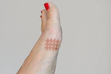 Lattice shaped tape stuck to women's foot