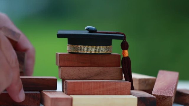 Graduation celebrating cap on wooden square blocks tower. Blank space for letter e.g education, study plan, graduate, etc. Ideas for Successive business abroad international Educational